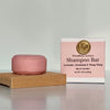 Pink shampoo bar on a wooden stand with a pink label in the background