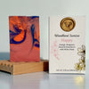 Marbled soap bar on a wooden stand with 'Woodland Sunrise Happy' packaging.