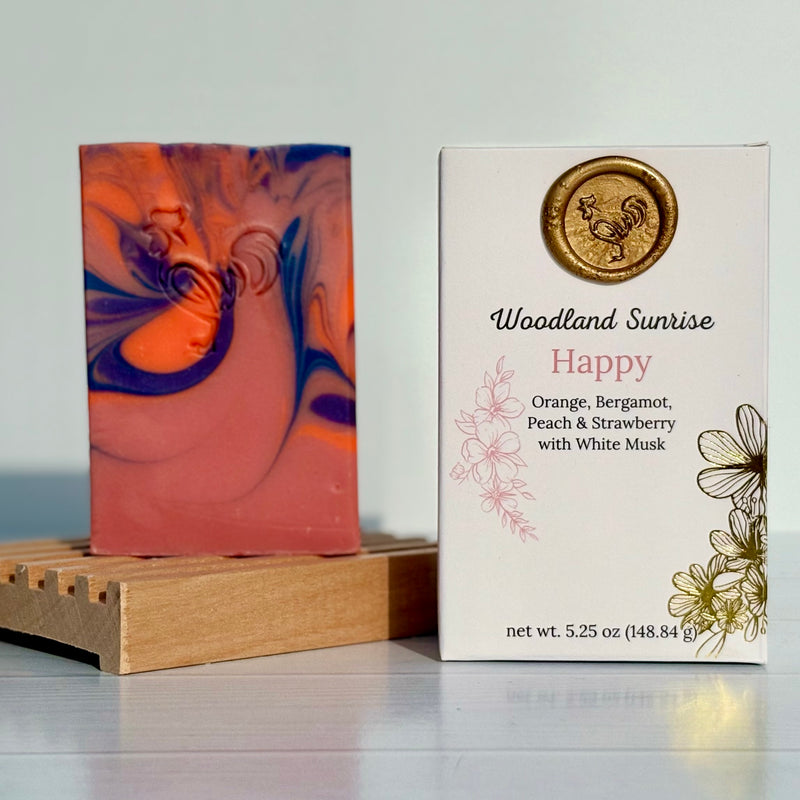 Marbled soap bar on a wooden stand with 'Woodland Sunrise Happy' packaging.