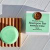 Shampoo bar with a wooden block and label on a light wooden surface