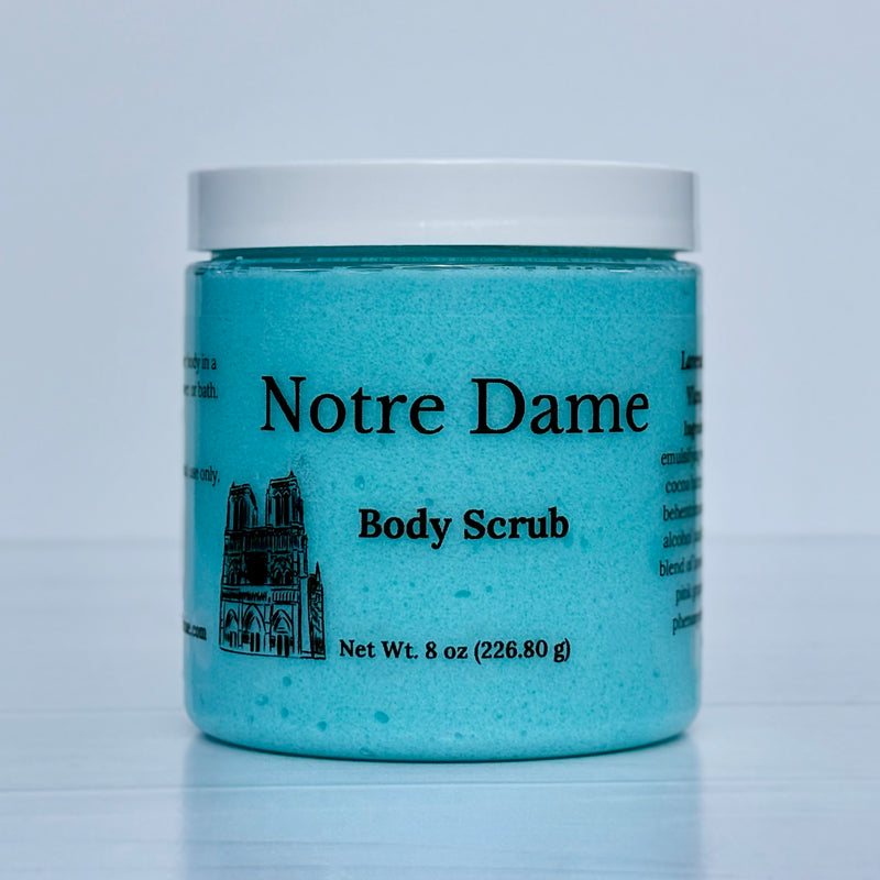 Jar of Notre Dame Body Scrub with blue contents and white lid on a light gray background