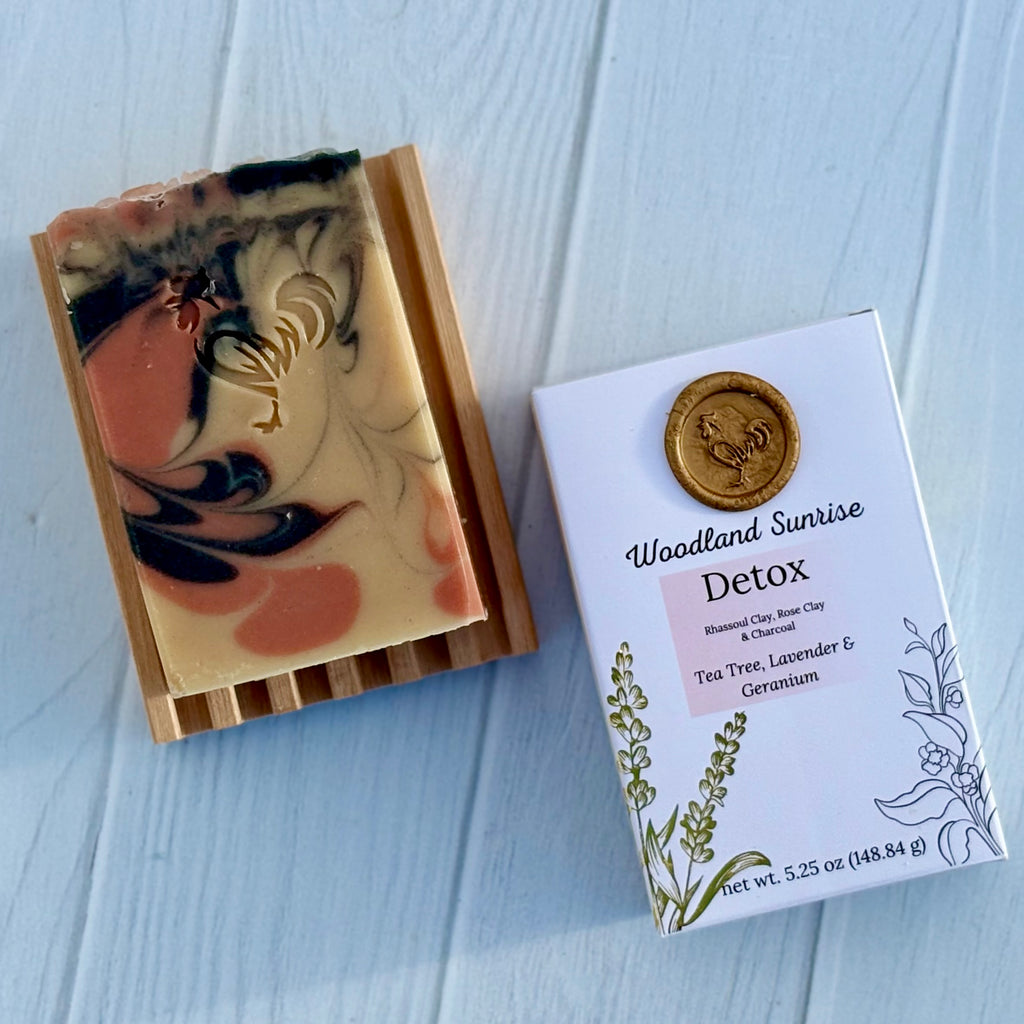 Marbled soap bar next to its packaging on a light wooden surface