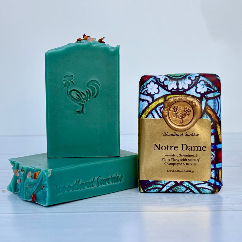 Two bars of soap, one green and one with a colorful label, on a light gray background.