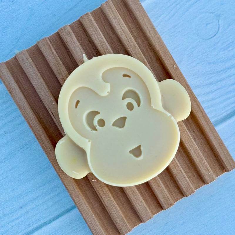 Set of four animal-shaped cookie cutters soap on a blue wooden surface