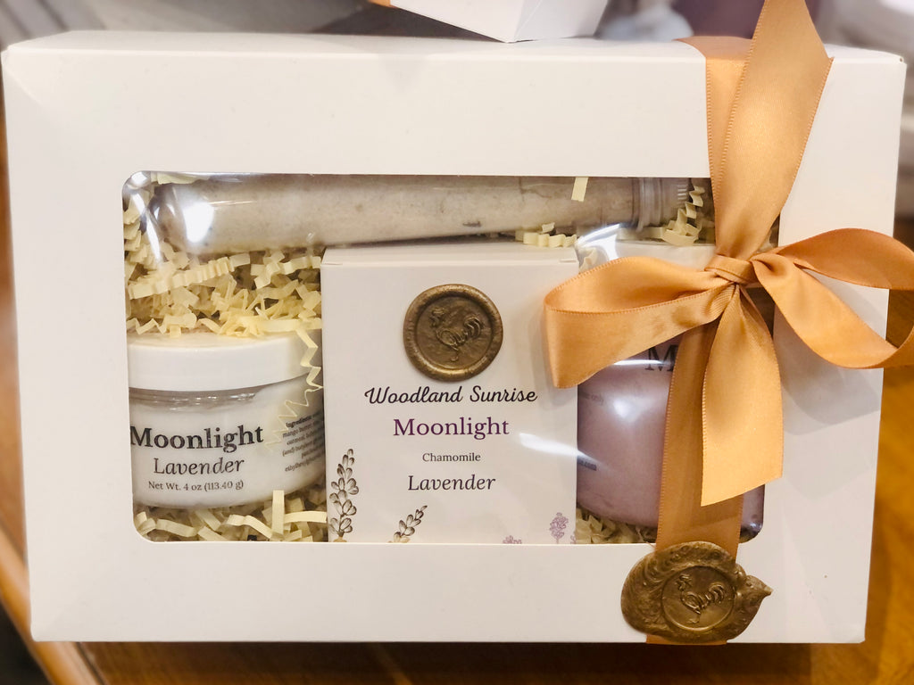 Moonlight gift set includes body cream, bar soap, body scrub, and bath soaking salts. Packaged in a box with a ribbon and wax seal. 